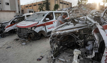 Palestinian paramedic inspects the remains of a destroyed ambulance by Israeli bombardment in Khan Yunis. (AFP)