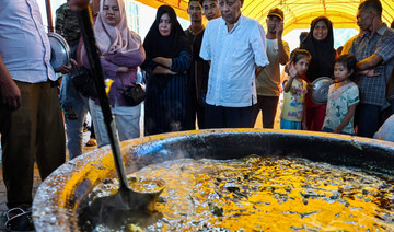 People look on as they wait to collect traditional curry dishes during Ramadan in Banda Aceh. (AFP)