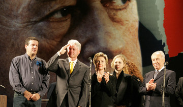 Standing in front of a huge image of assassinated former Israeli PM Yitzhak Rabin, Bill Clinton salutes in Tel Aviv. (AFP)